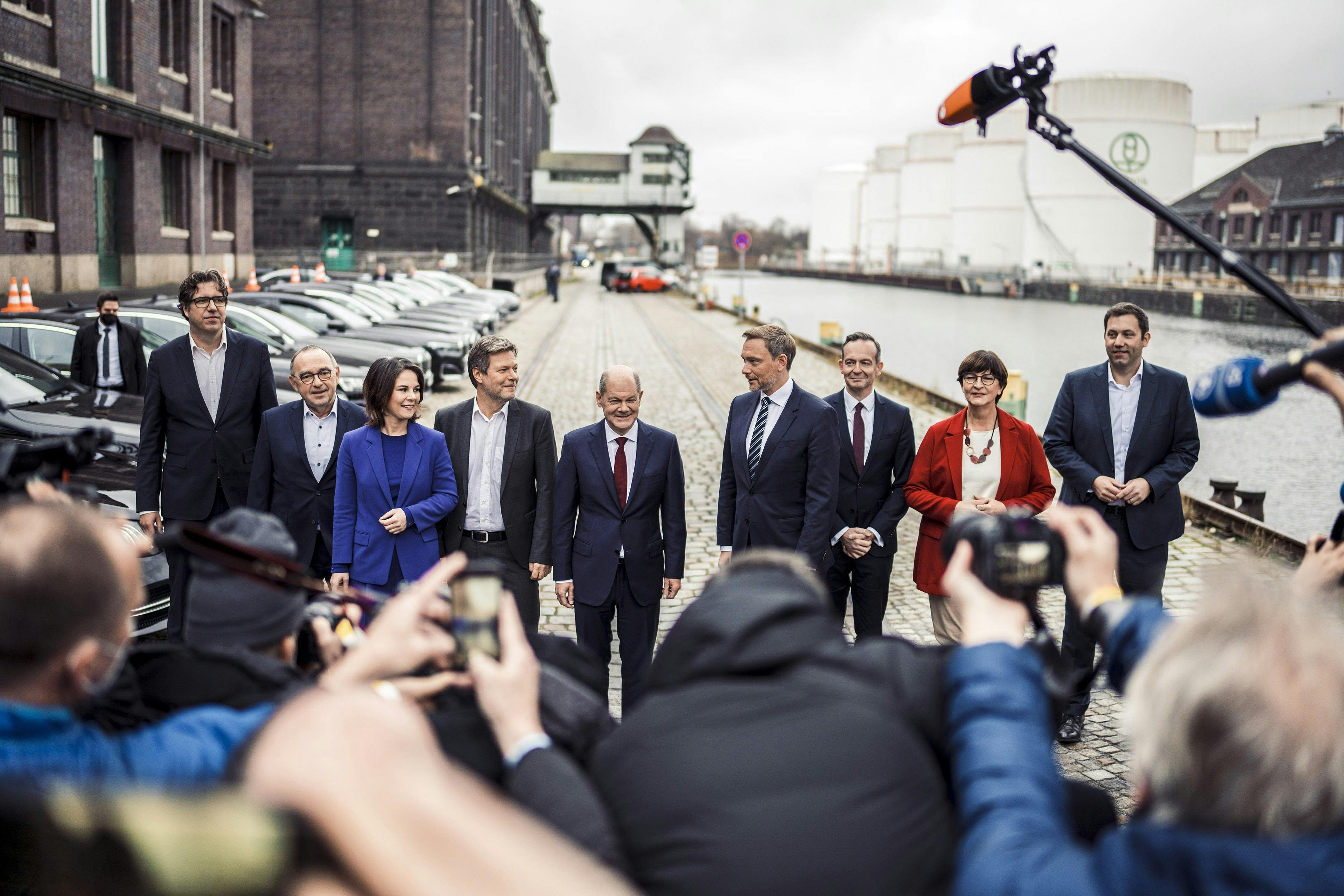 Politiker*innen von GRÜNEN, SPD und FDP stehen nebeneinander, vor ihnen viele Journalist*innen mt Kameras und Mikrofonen.
