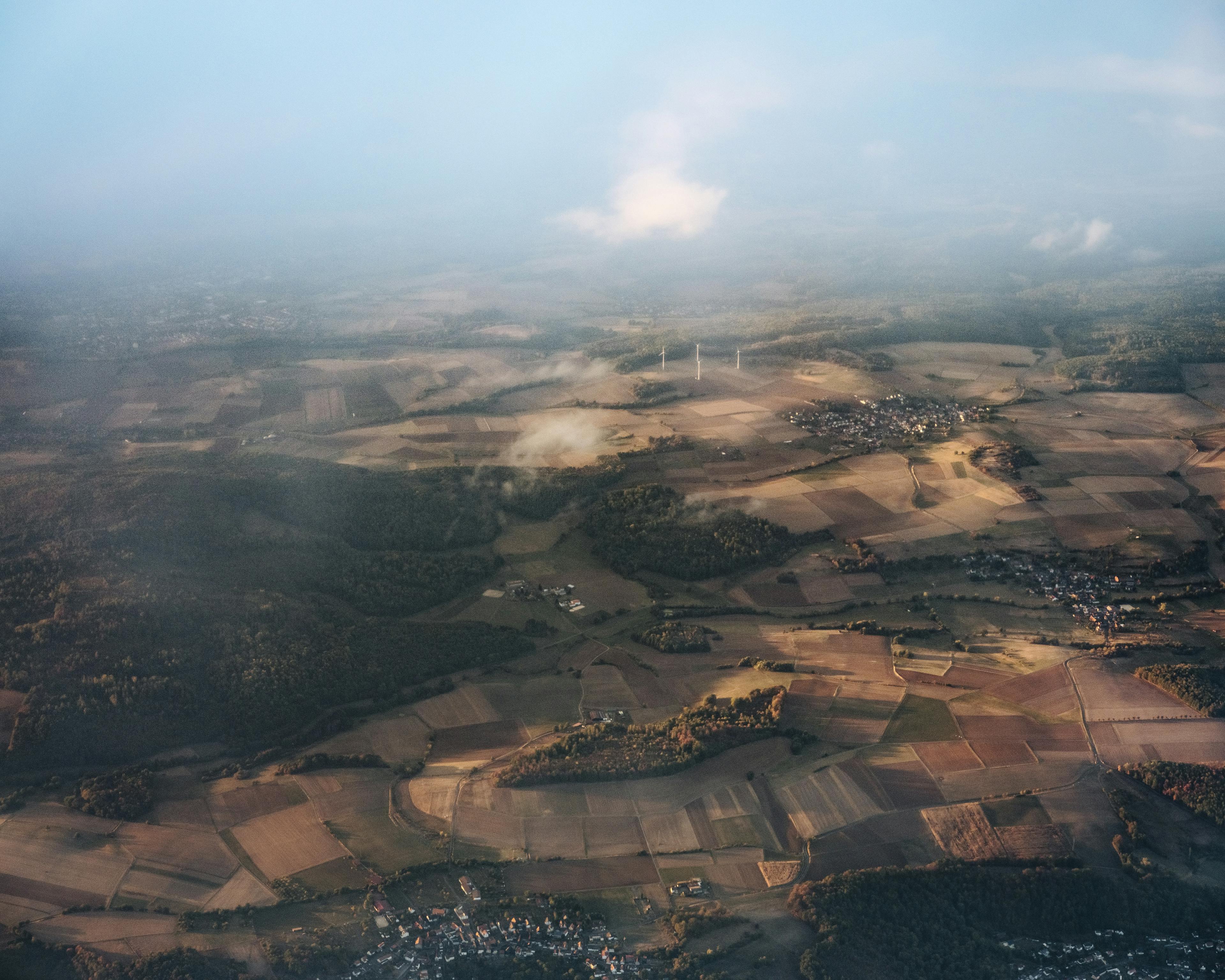 Eine Luftaufnahme von landwirtschaftlichen Flächen, Dörfern und Wäldern.
