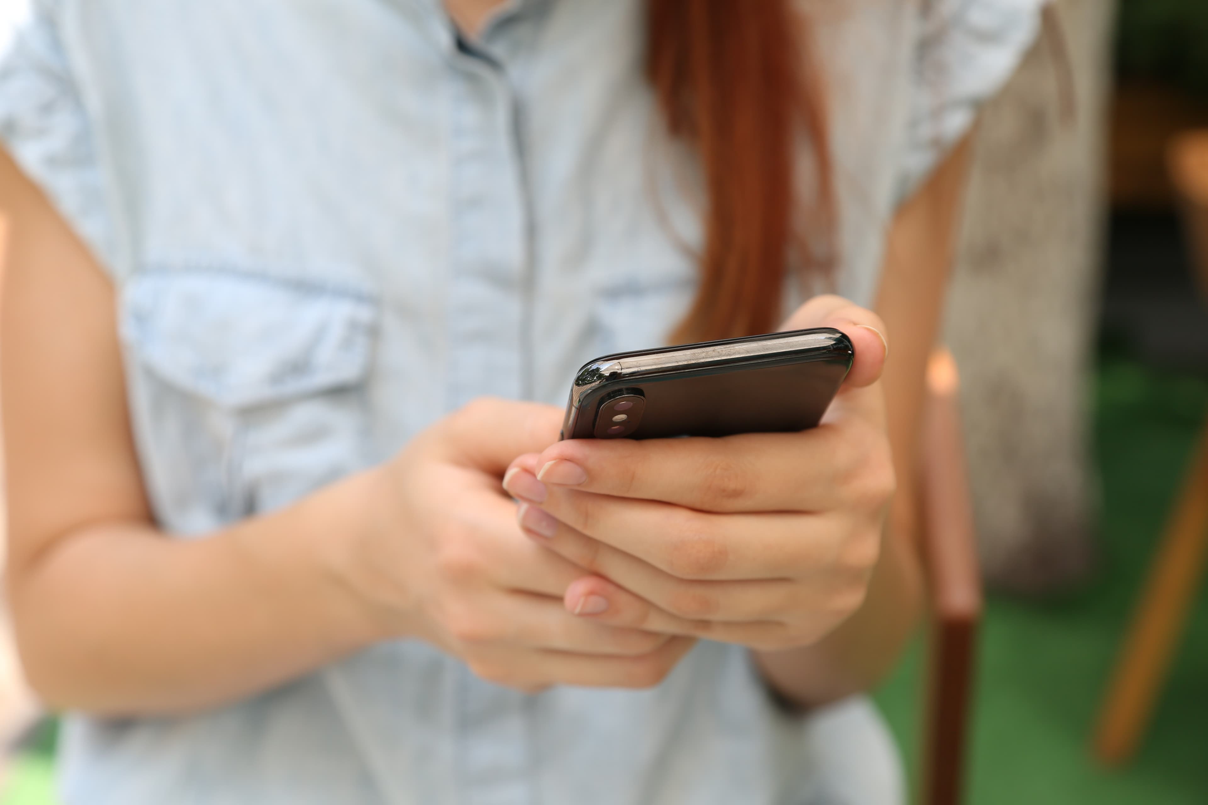 Frau mit Handy in den Händen, Nahaufnahme.