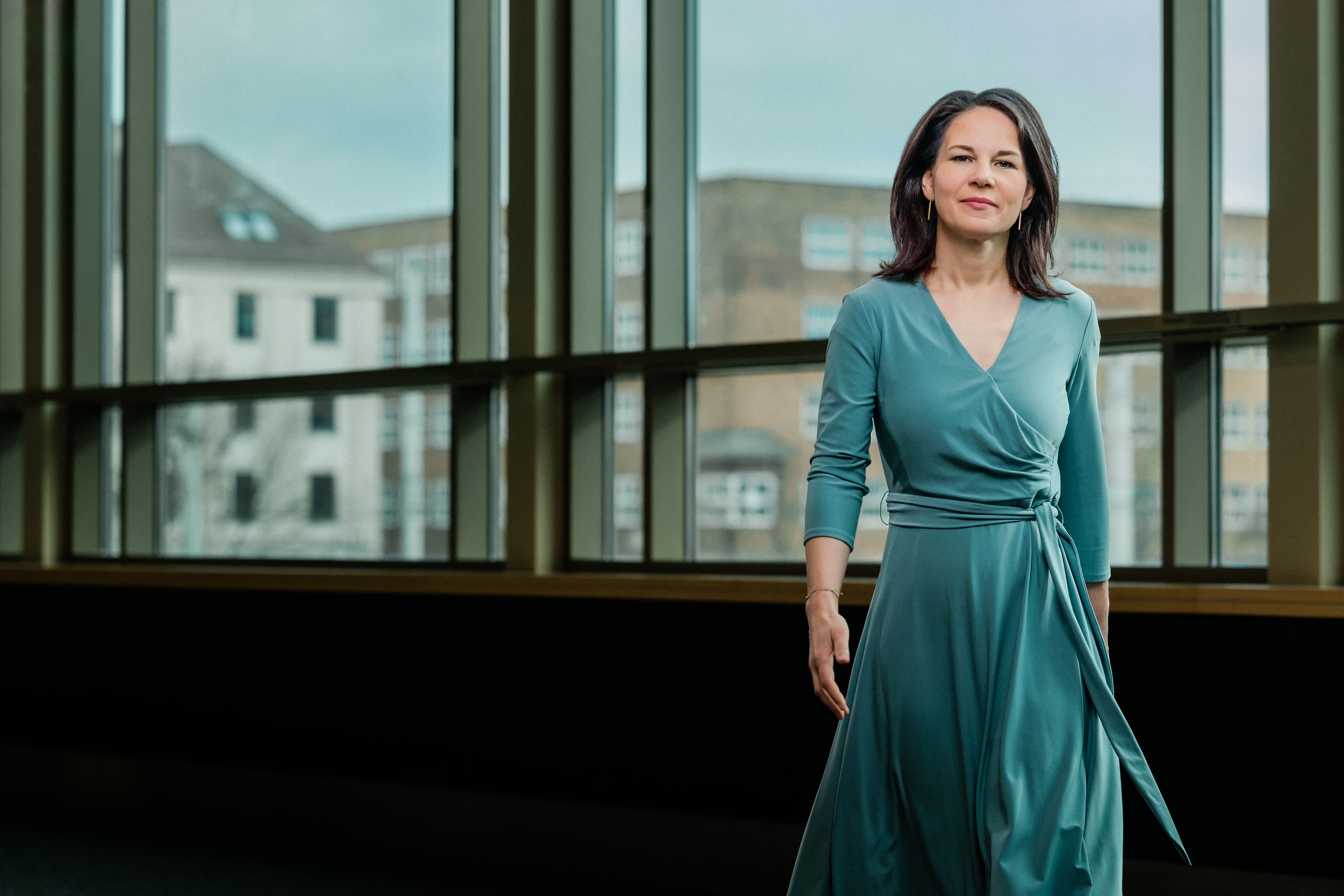 Außenministerin Annalena Baerbock in blauem Kleid, laufend.