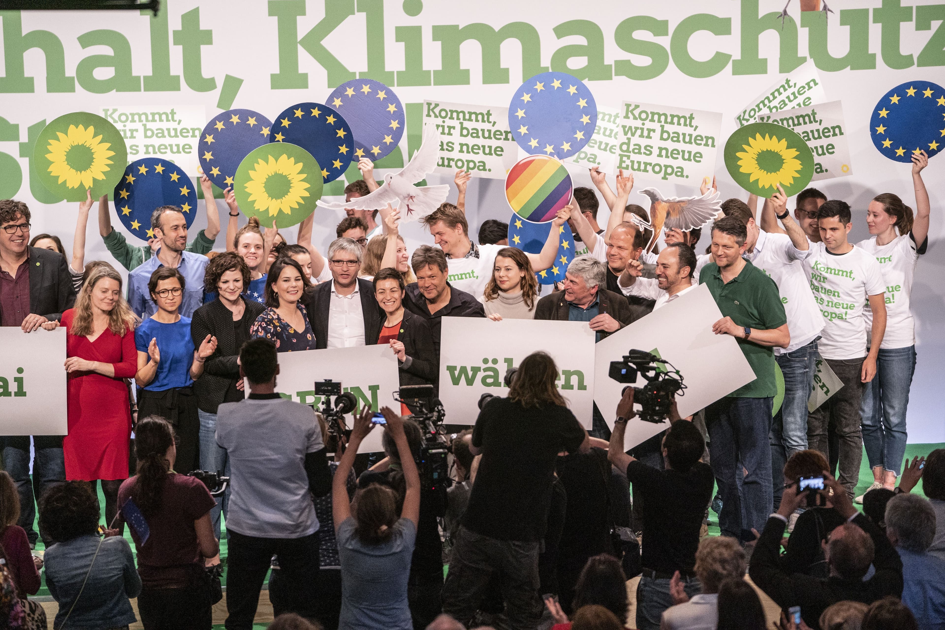 Viele GRÜNE auf einer Bühne mit Schildern, auf denen steht: Grün wählen.