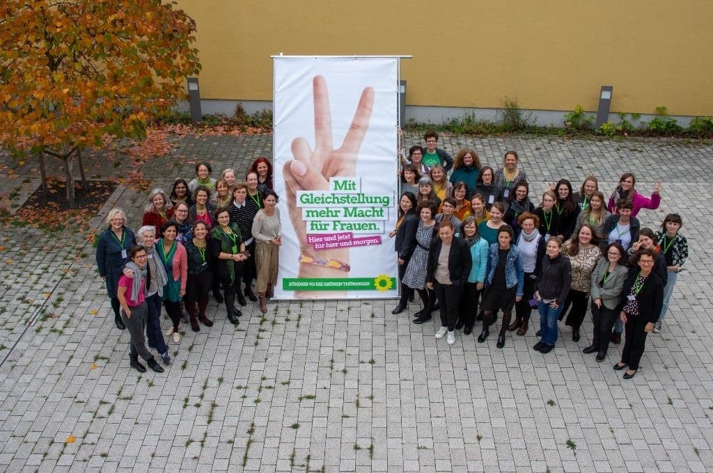 Eine Luftaufnahme von vielen Frauen, die in einem Hof stehen mit einem großen Banner in der Mitte.