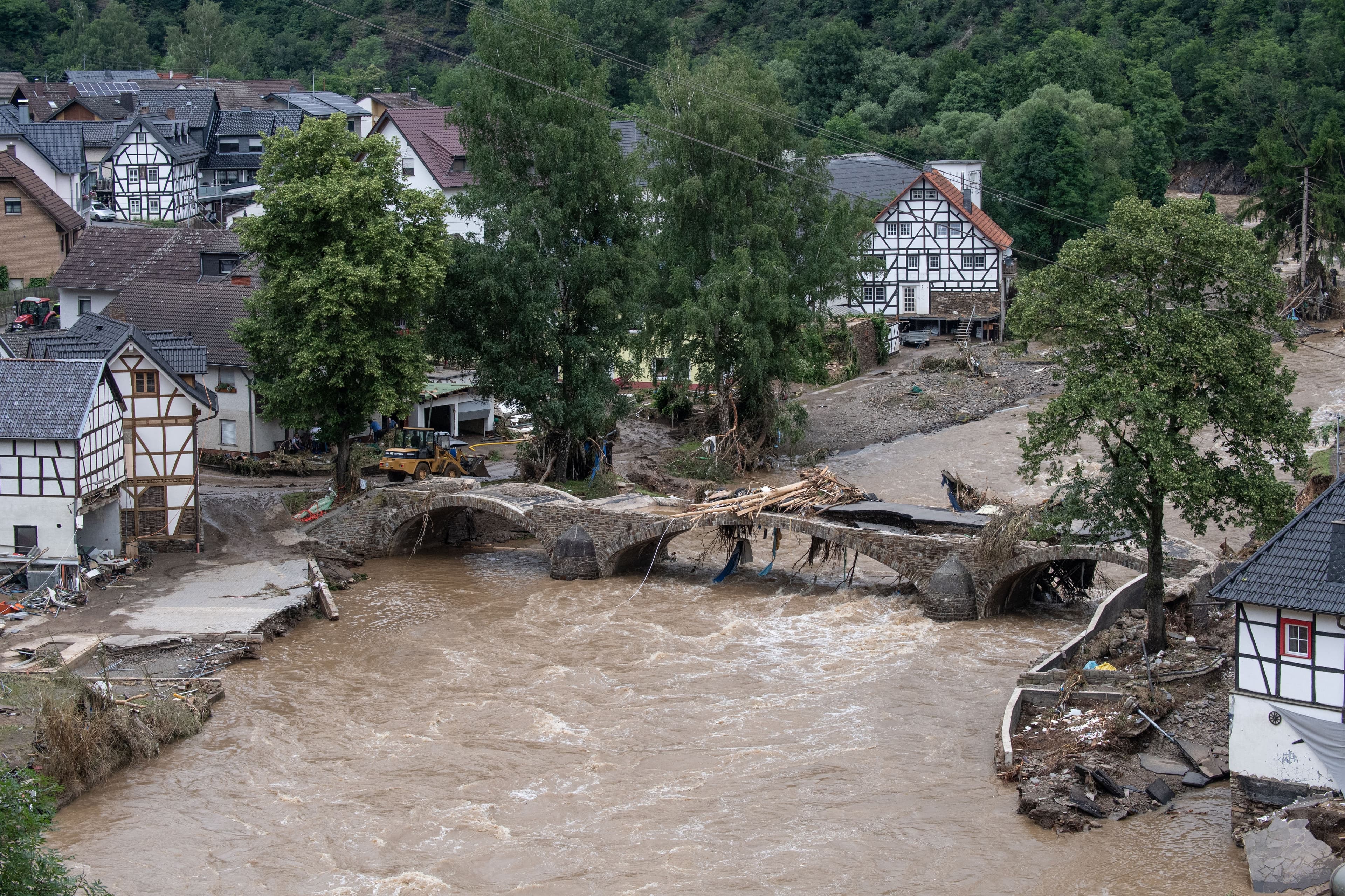 Ein Fluss ist über das Ufer getreten und hat eine Brücke zum einsturz gebracht.