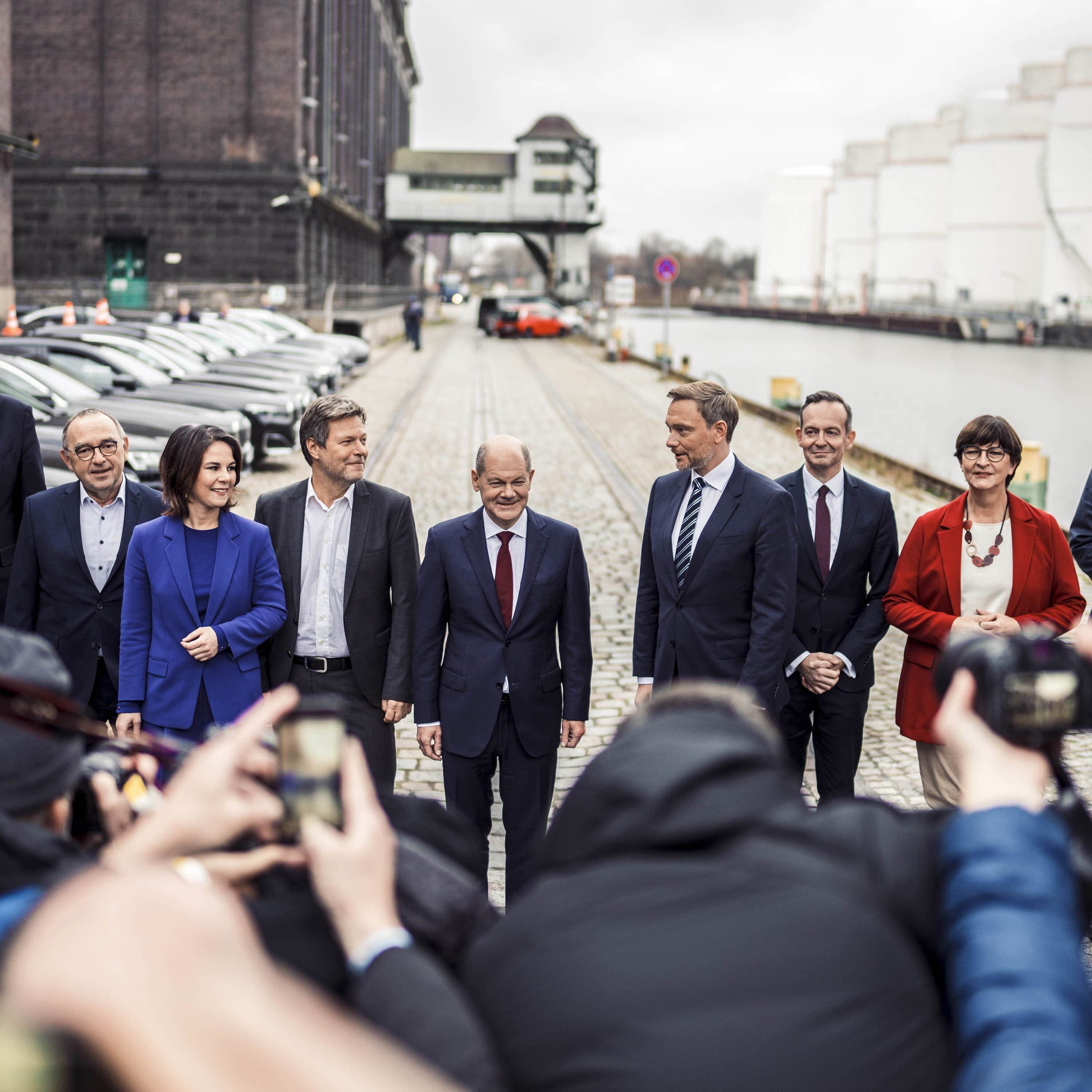 Politiker*innen von GRÜNEN, SPD und FDP stehen nebeneinander, vor ihnen viele Journalist*innen mt Kameras und Mikrofonen.