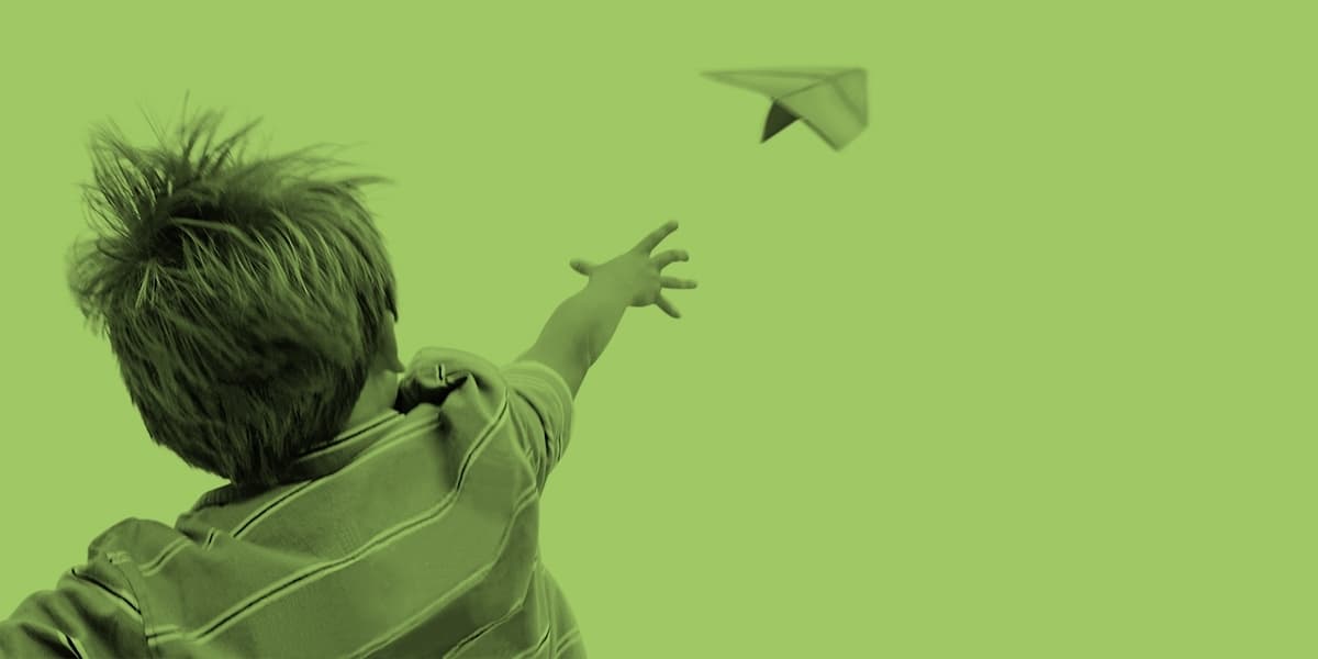 Kind lässt Papierflieger fliegen