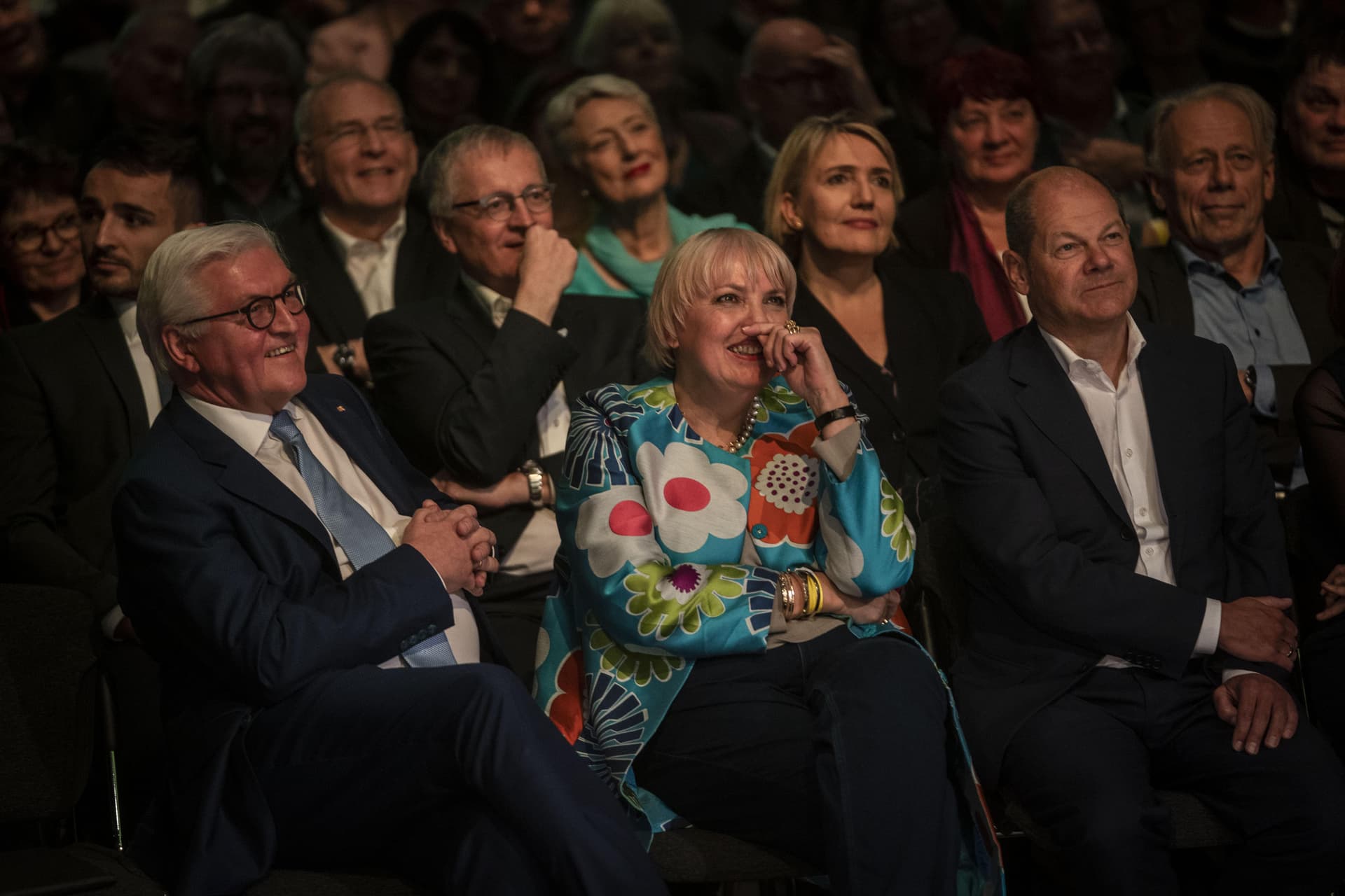 Bundespräsident Frank-Walter Steinmeier sitzend im Publikum neben Claudia Roth und Olaf Scholz.