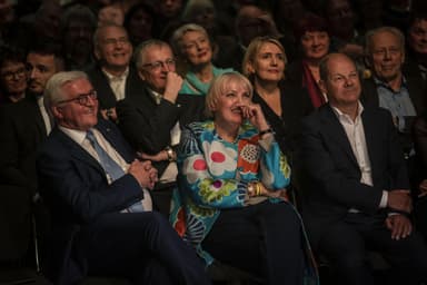 Bundespräsident Frank-Walter Steinmeier sitzend im Publikum neben Claudia Roth und Olaf Scholz.