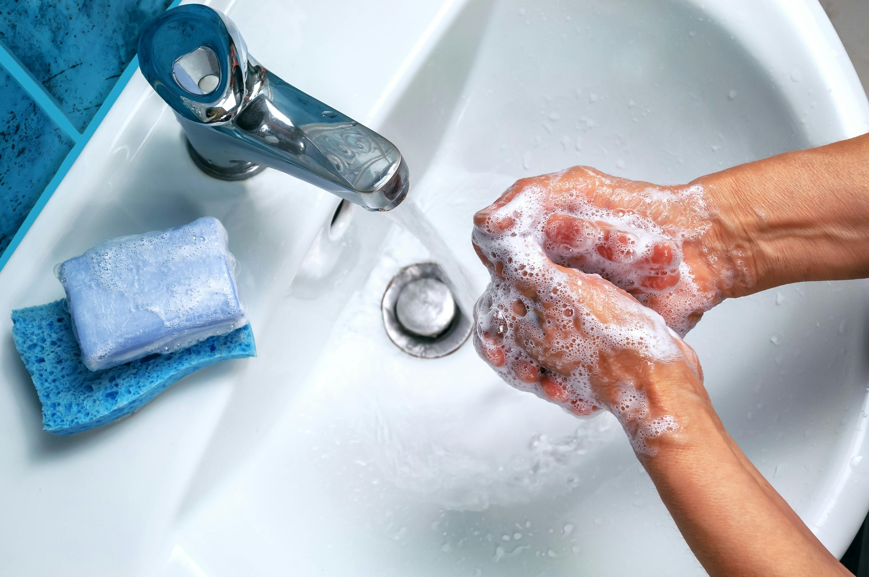 Eine Person wäscht sich über einem Waschbecken die Hände.