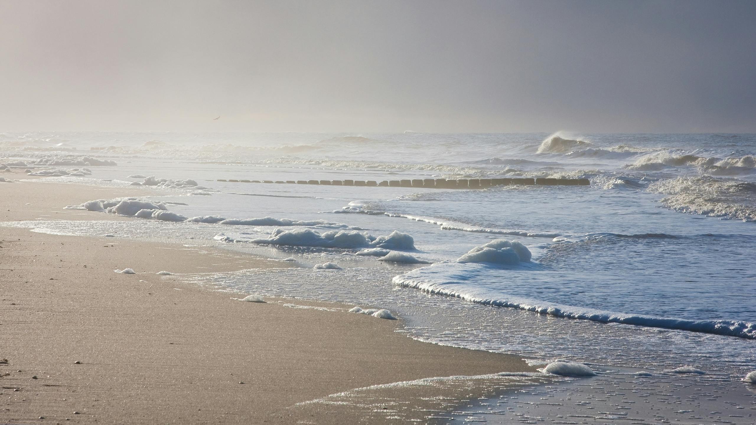 Sandstrand und Meer mit Wellen