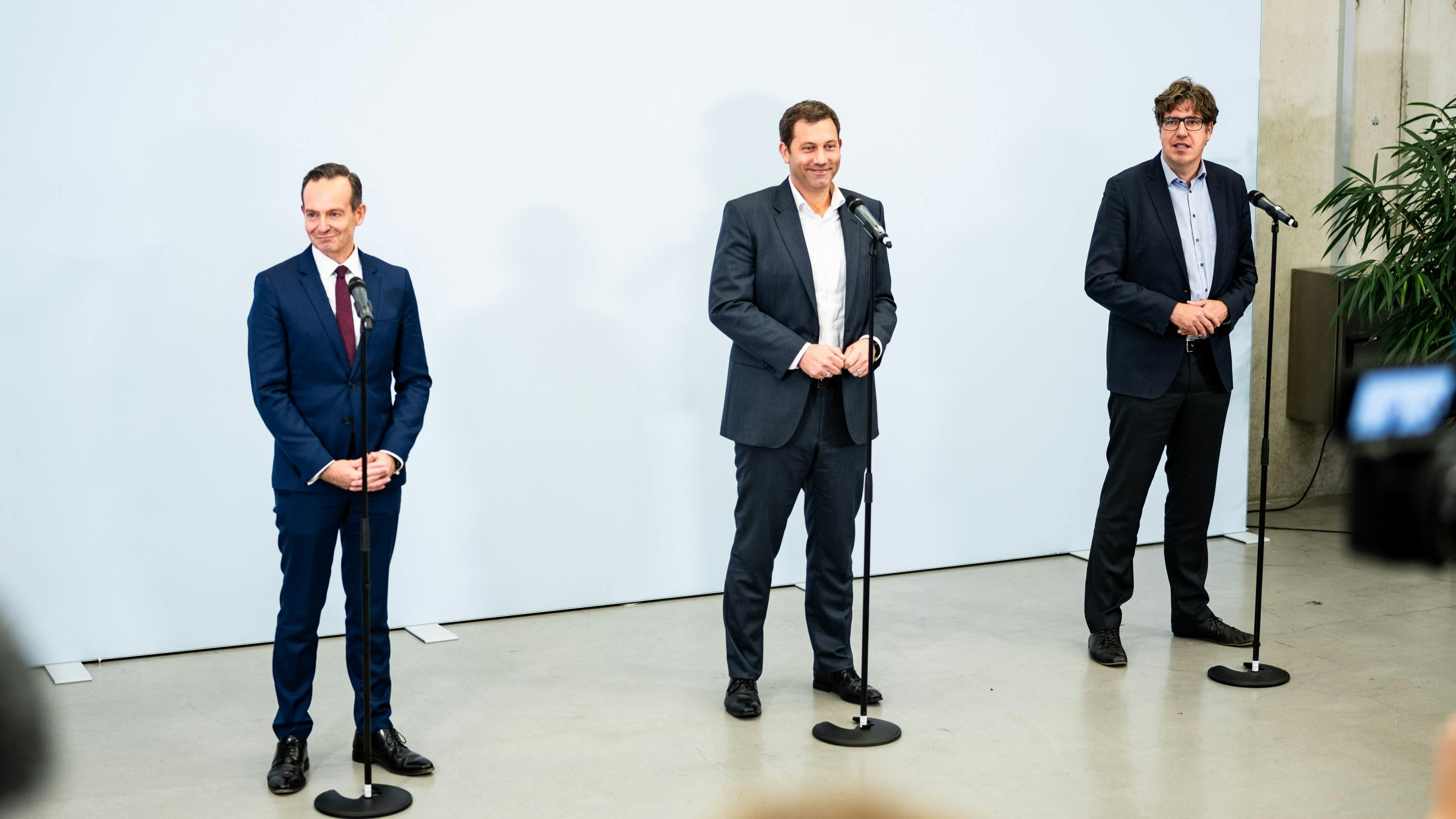Volker Wissing (FDP), Lars Klingbeil (SPD) und Michael Kellner (GRÜNE) stehen für ein Statement nebeneinander an Mikrofonen.