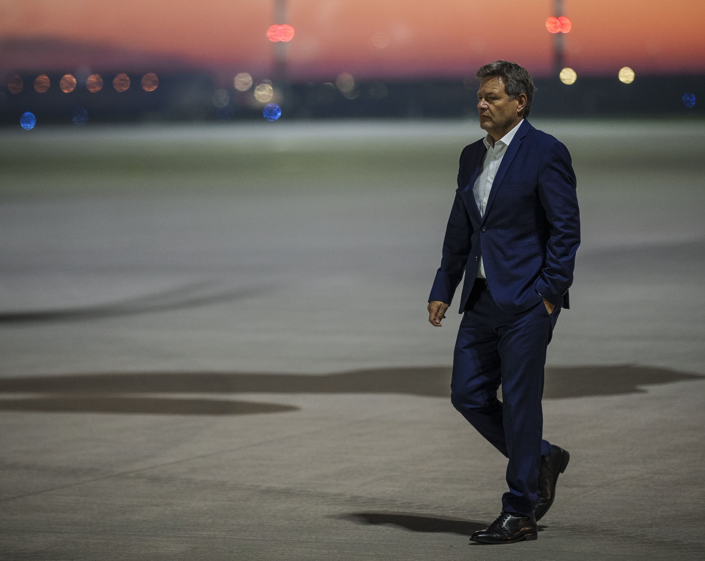 Robert Habeck läuft über ein Rollfeld am Flughafen.