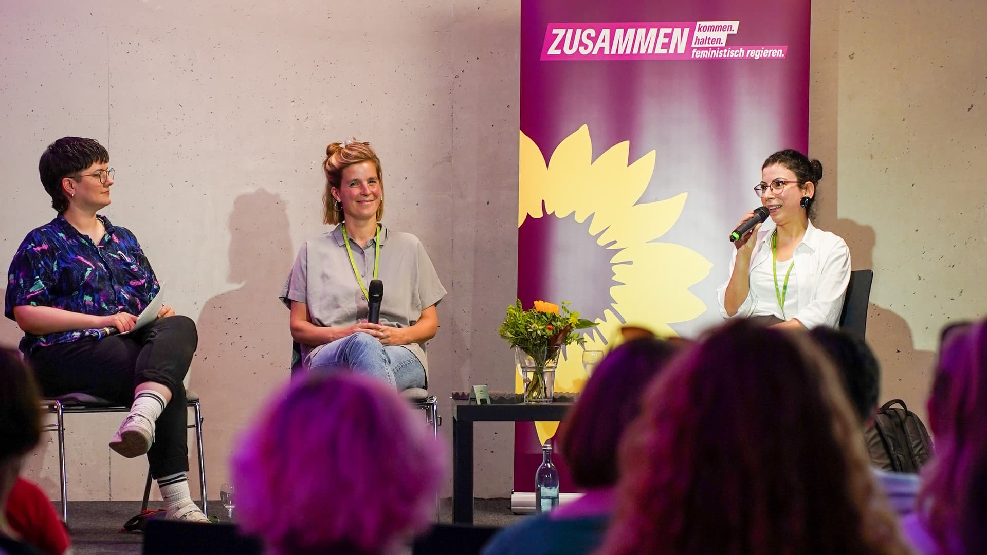 Drei Fraue nehmen an einer Podiumsdiskussion teil.