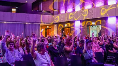 Abstimmung einer Gruppe von Frauen in einem Saal.