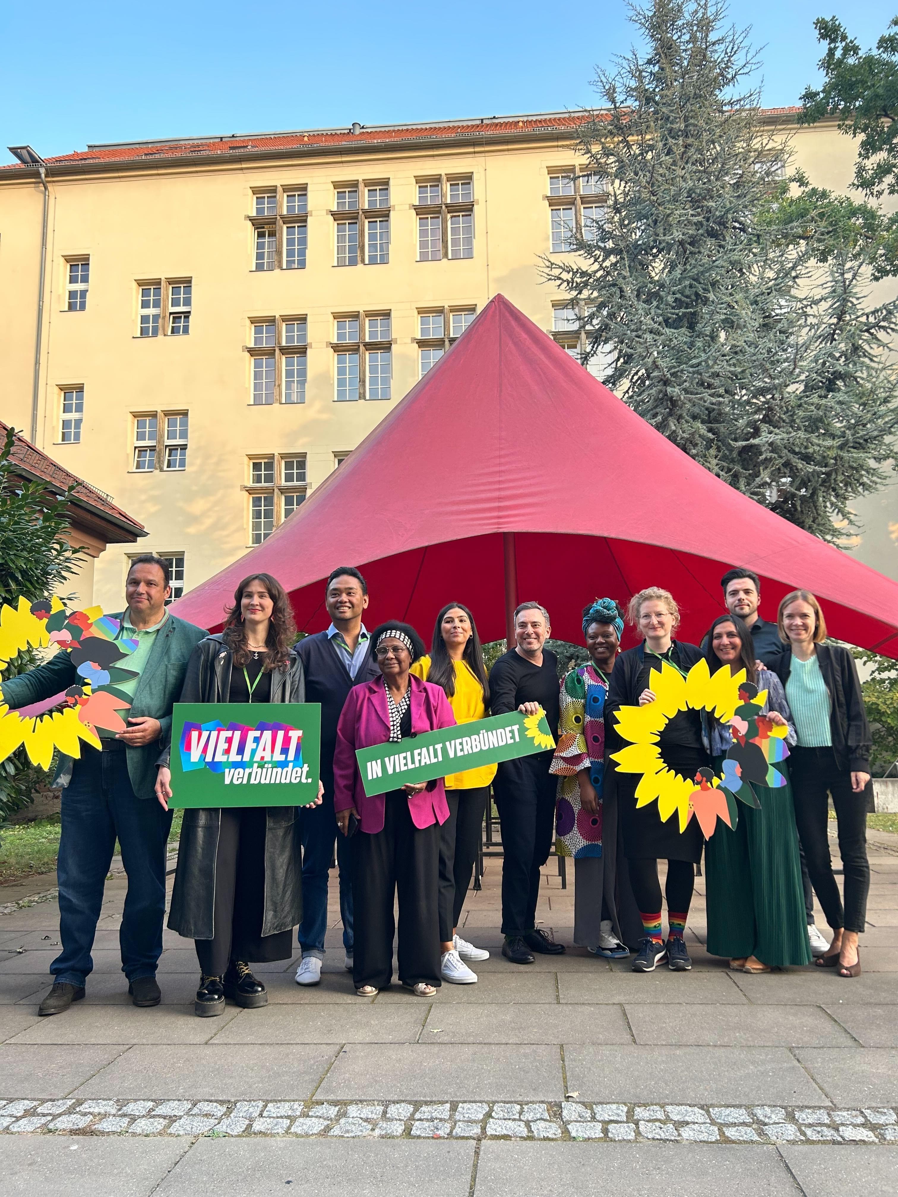 Ein Gruppe Menschen posiert mit grünen Plakaten für ein Bild.