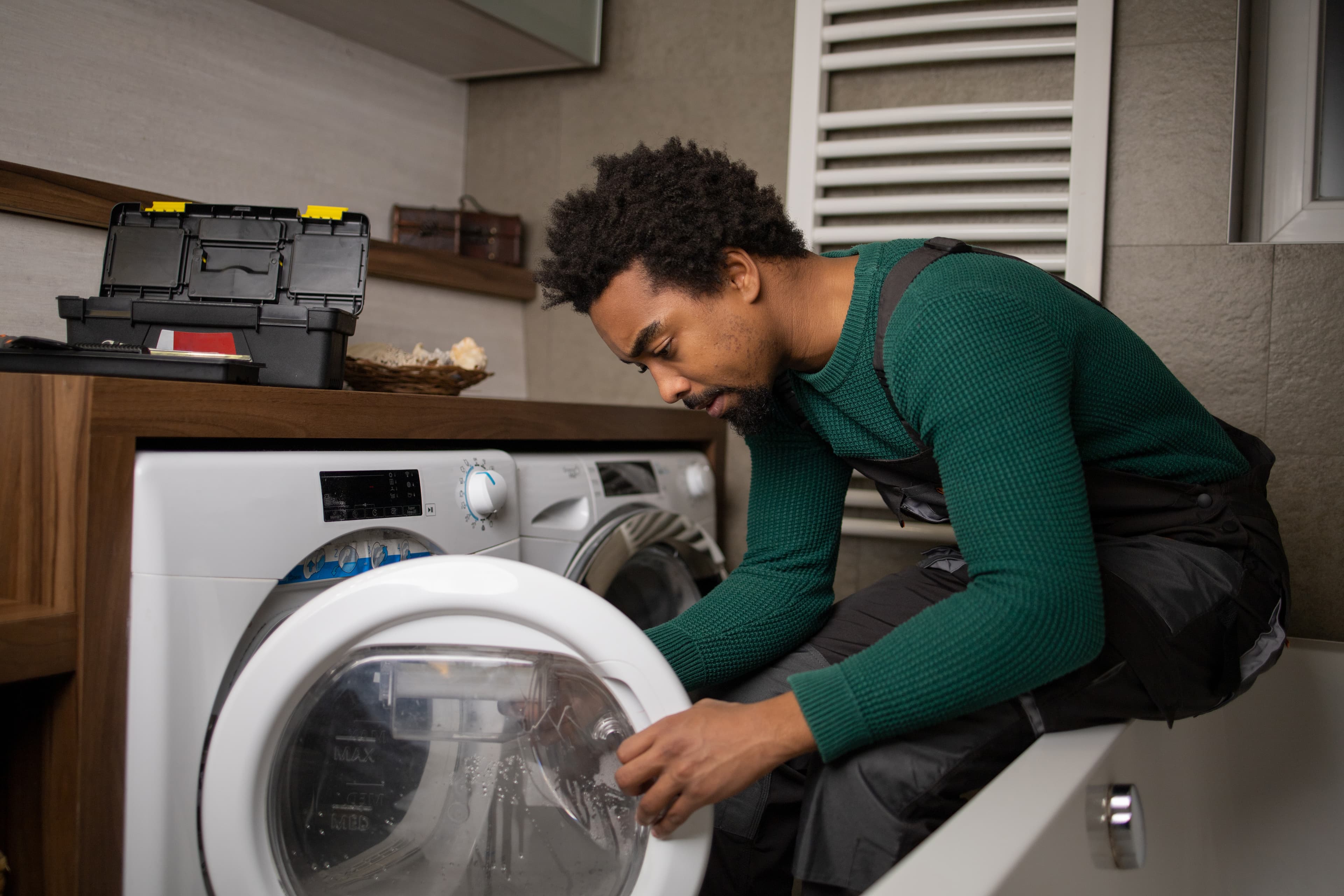 EIn Handwerker repariert eine Waschmaschine