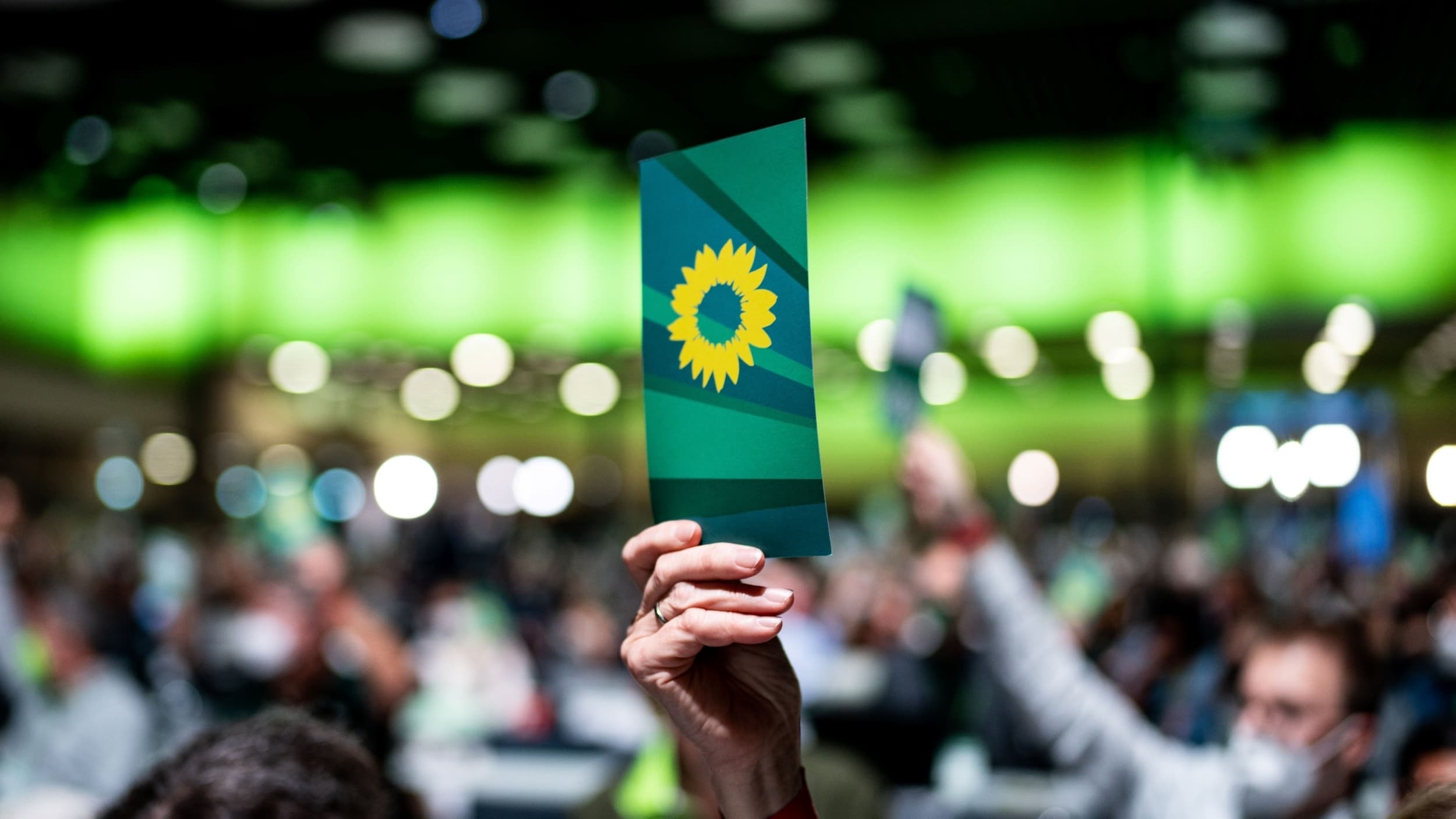 Person hebt Karte zur Abstimmung