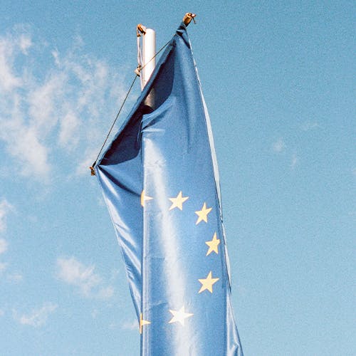 Die Europaflagge weht am Mast vor blauem Himmel.