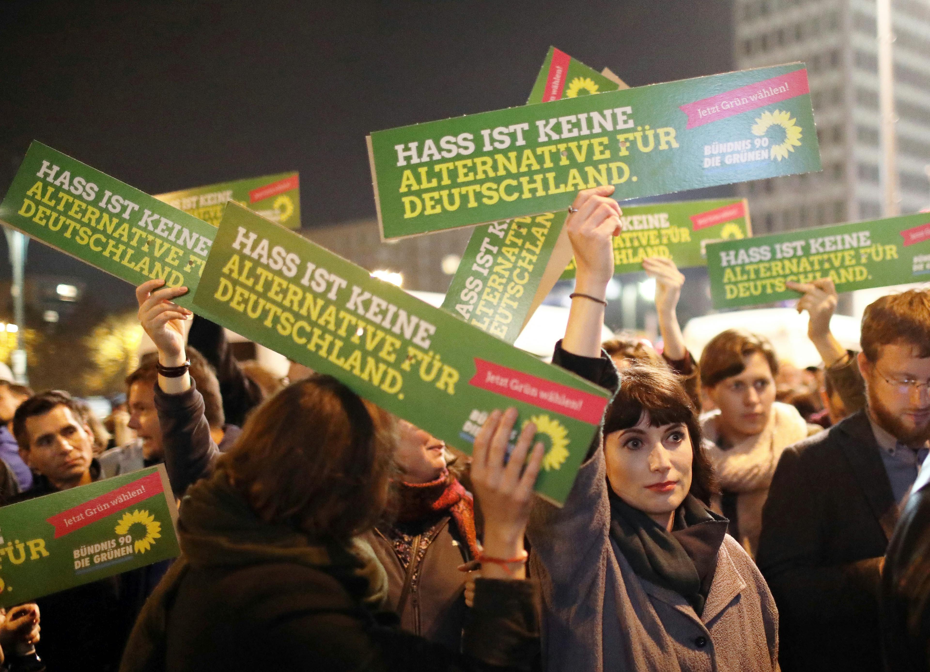 Personen, die bei einer Demo Schilder hochhalten. Text: "Hass ist keine Alternative für Deutschland."