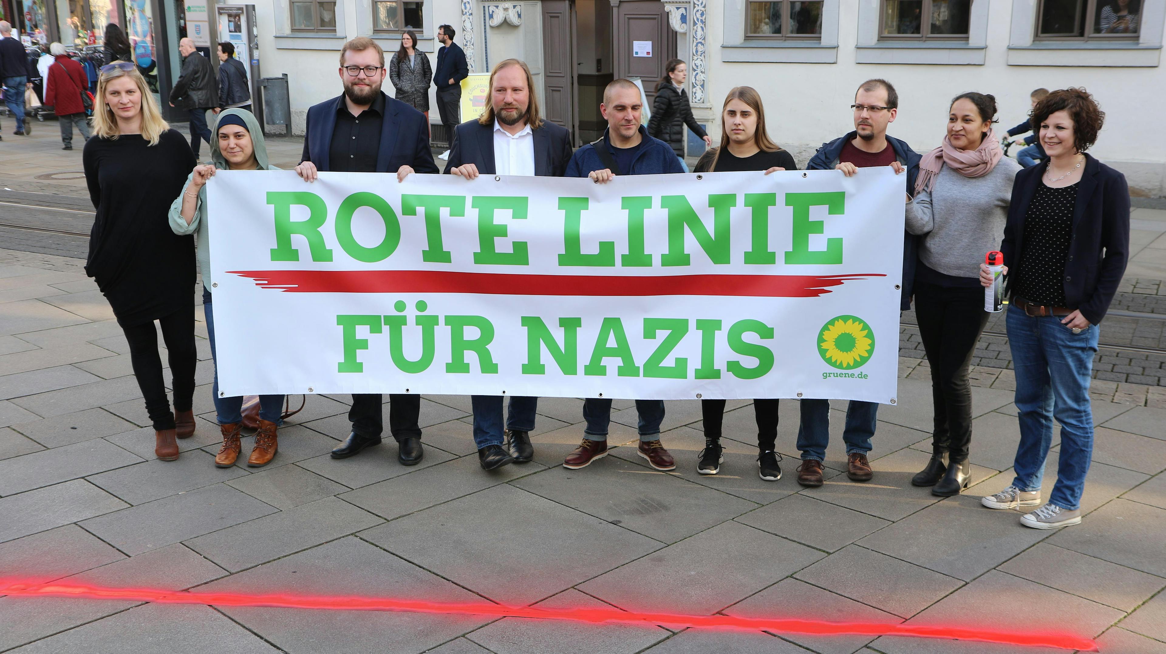 Mehrere Menschen halten ein Banner mit der Aufschrift "Rote Linie für Nazis", davor ist auf den Boden eine rote Linie gesprayt.