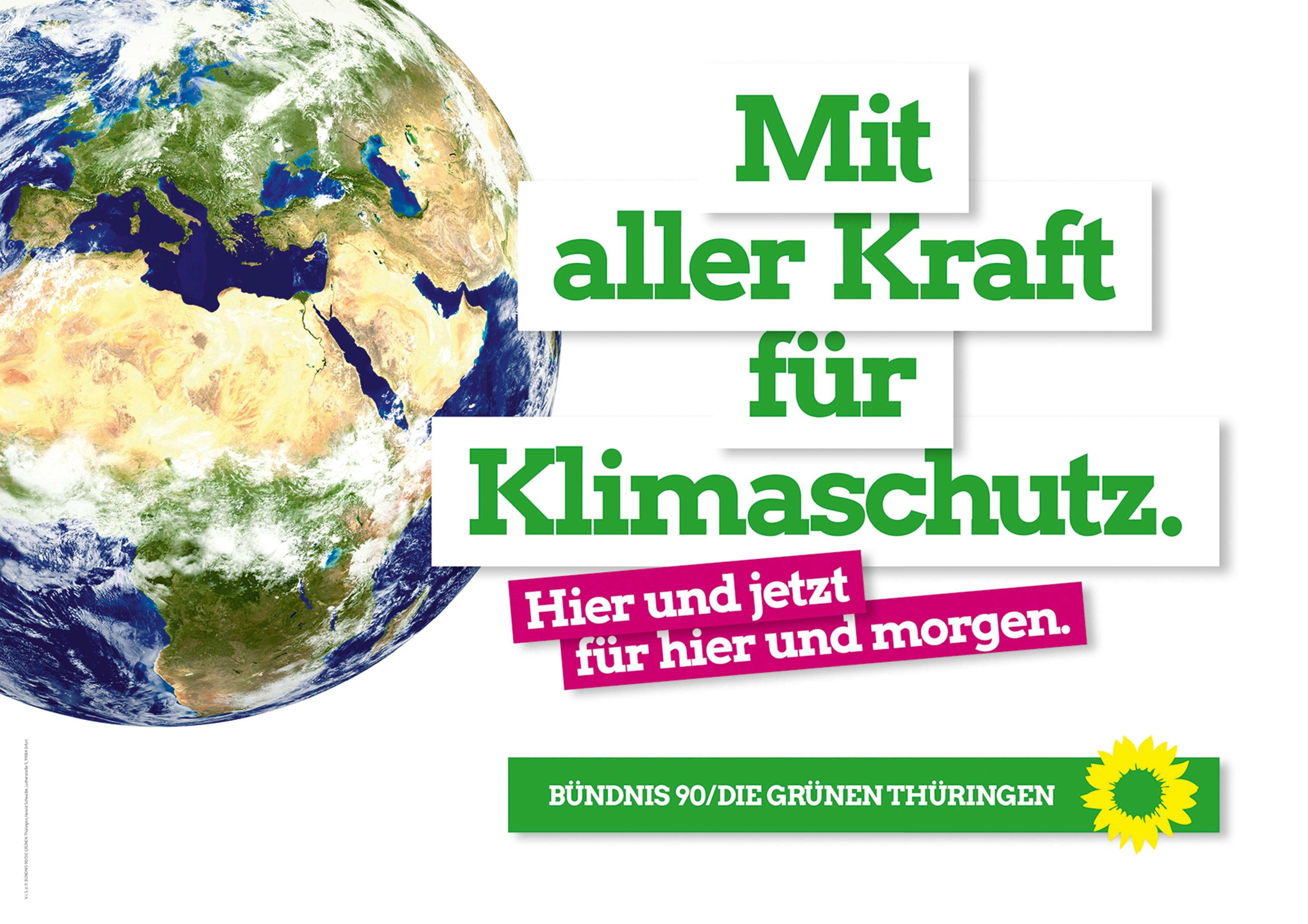 Eine große Erdkugel auf einem Plakat mit weißem Hintergrund. Daneben der Text: Mit aller Kraft für Klimaschutz. Hier und jetzt für hier und morgen. BÜNDNIS 90/DIE GRÜNEN Thüringen.