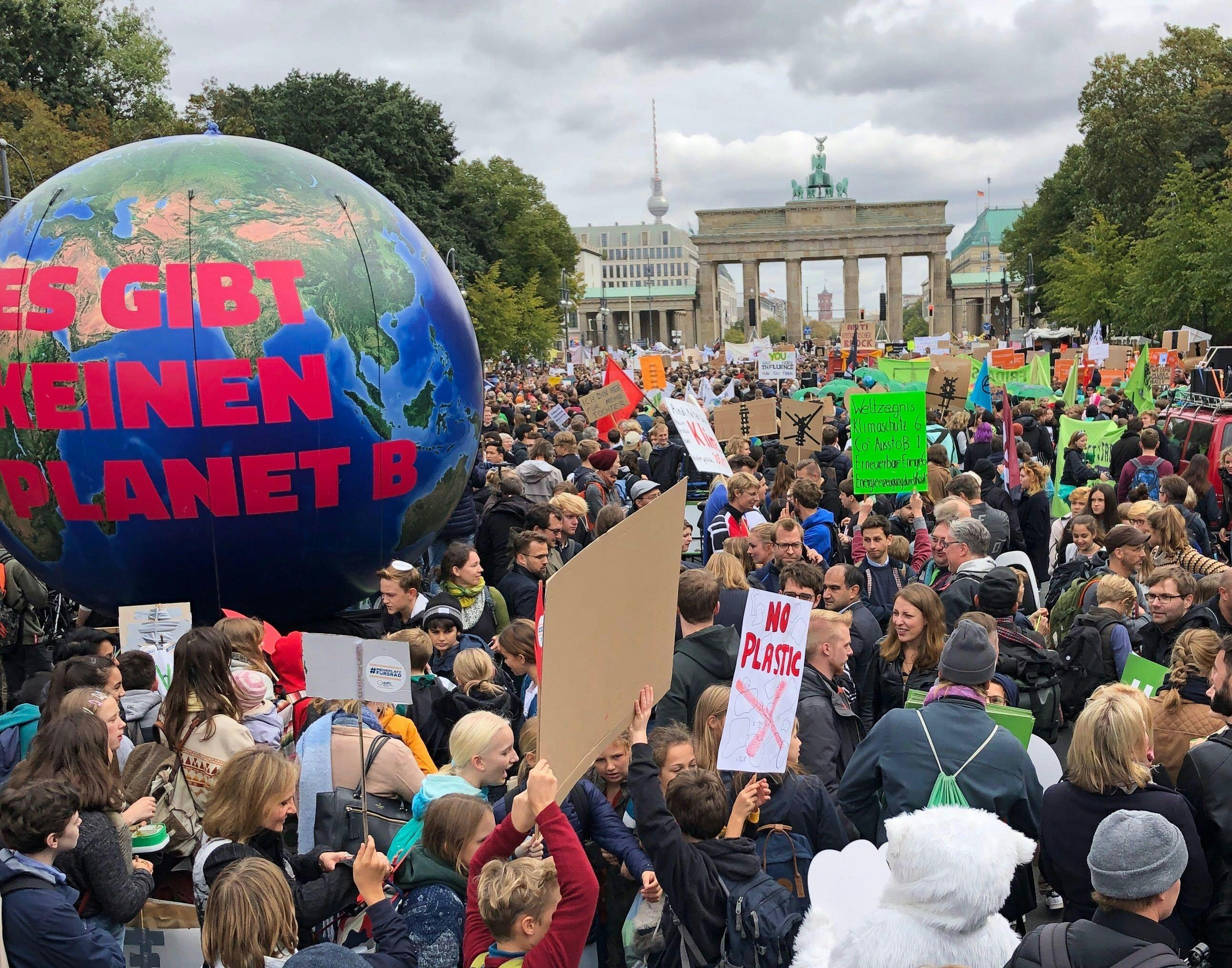 Eine große Menschenmenge demonstriert mit Schildern vor dem Brandenburger Tor. Es ist eine große Erdkugel zu sehen mit der Aufschrift: "Es gibt keinen Planet B"