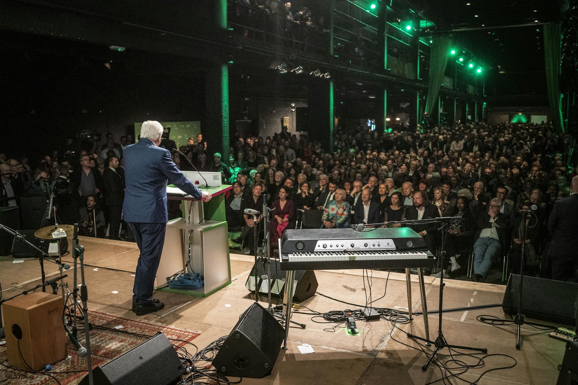 Bundespräsident Frank-Walter Steinmeier bei seiner Rede von hinten fotografiert mit Blick auf das Publikum.