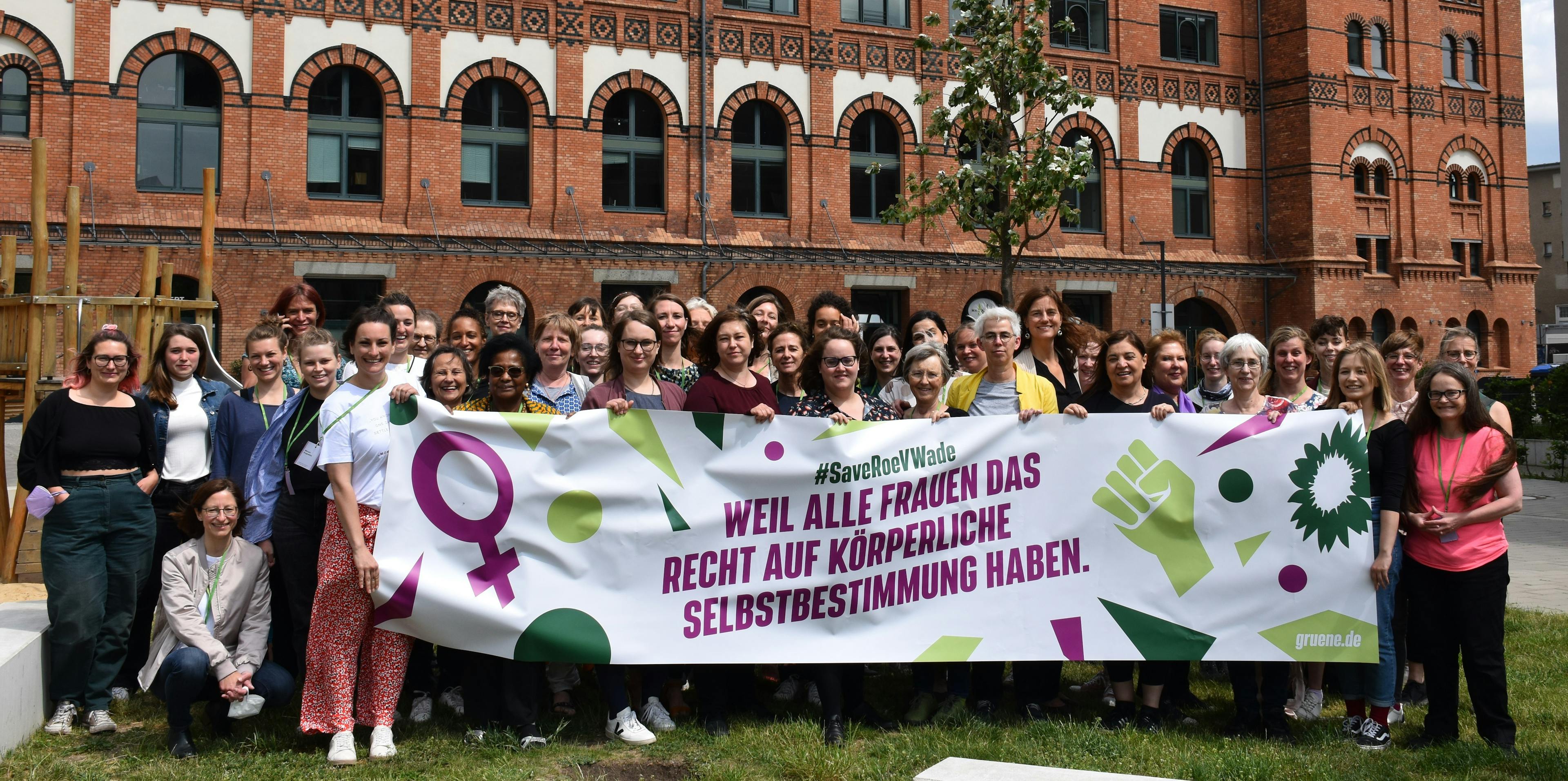 Gruppenfoto mit Banner "Weil alle Frauen das Recht auf körperliche Selbstbestimmung haben"